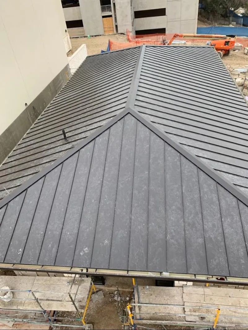 Commercial metal roof construction with crane equipment in Long View